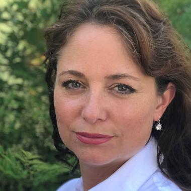 Woman with long brown hair and a white collared shirt