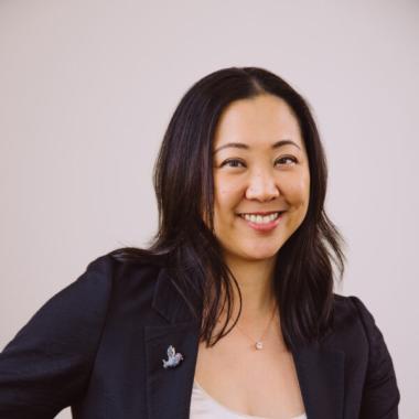 woman with brown hair, blue blazer and white shirt